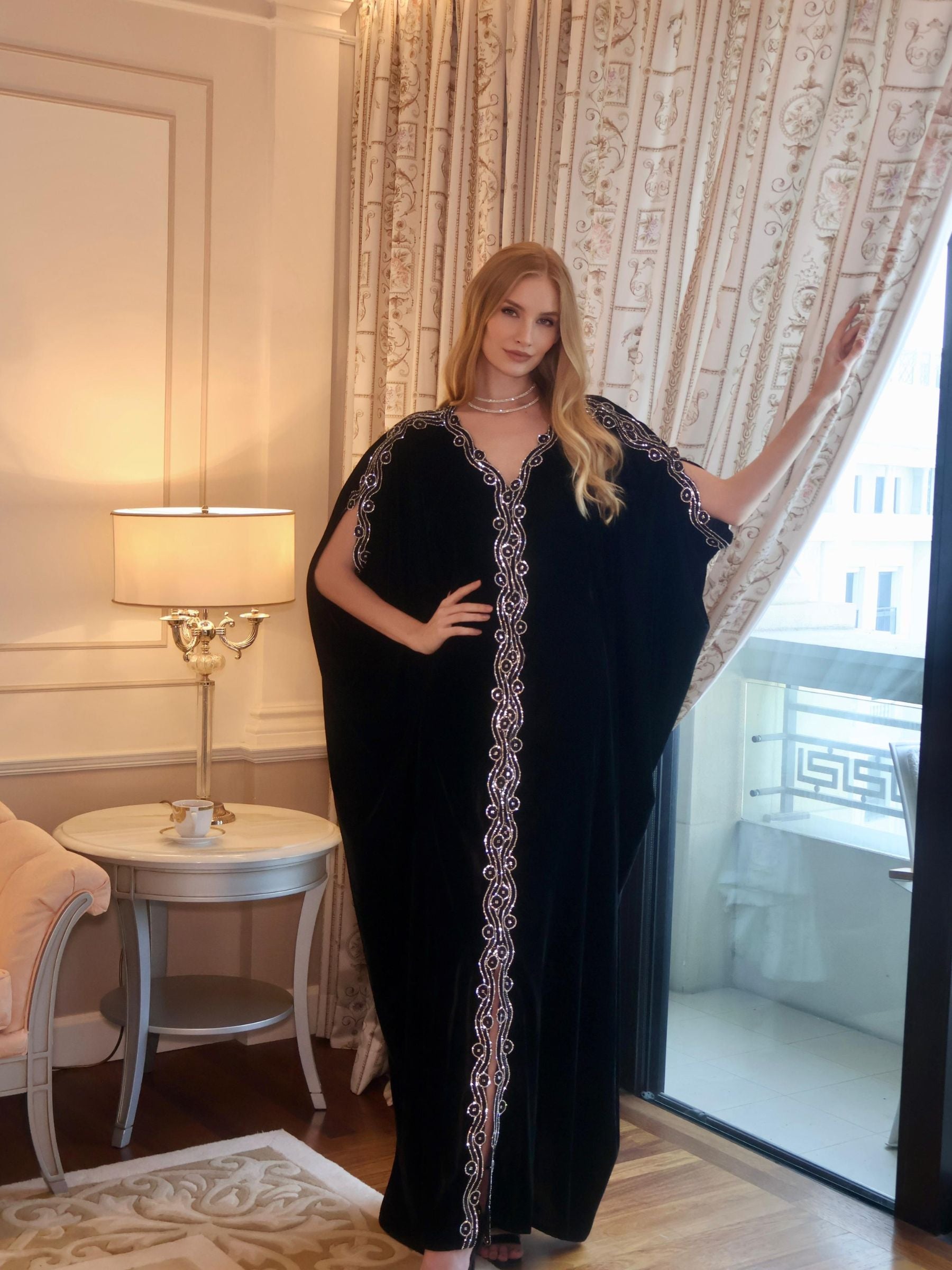 Woman in a black dress with white embroidery.