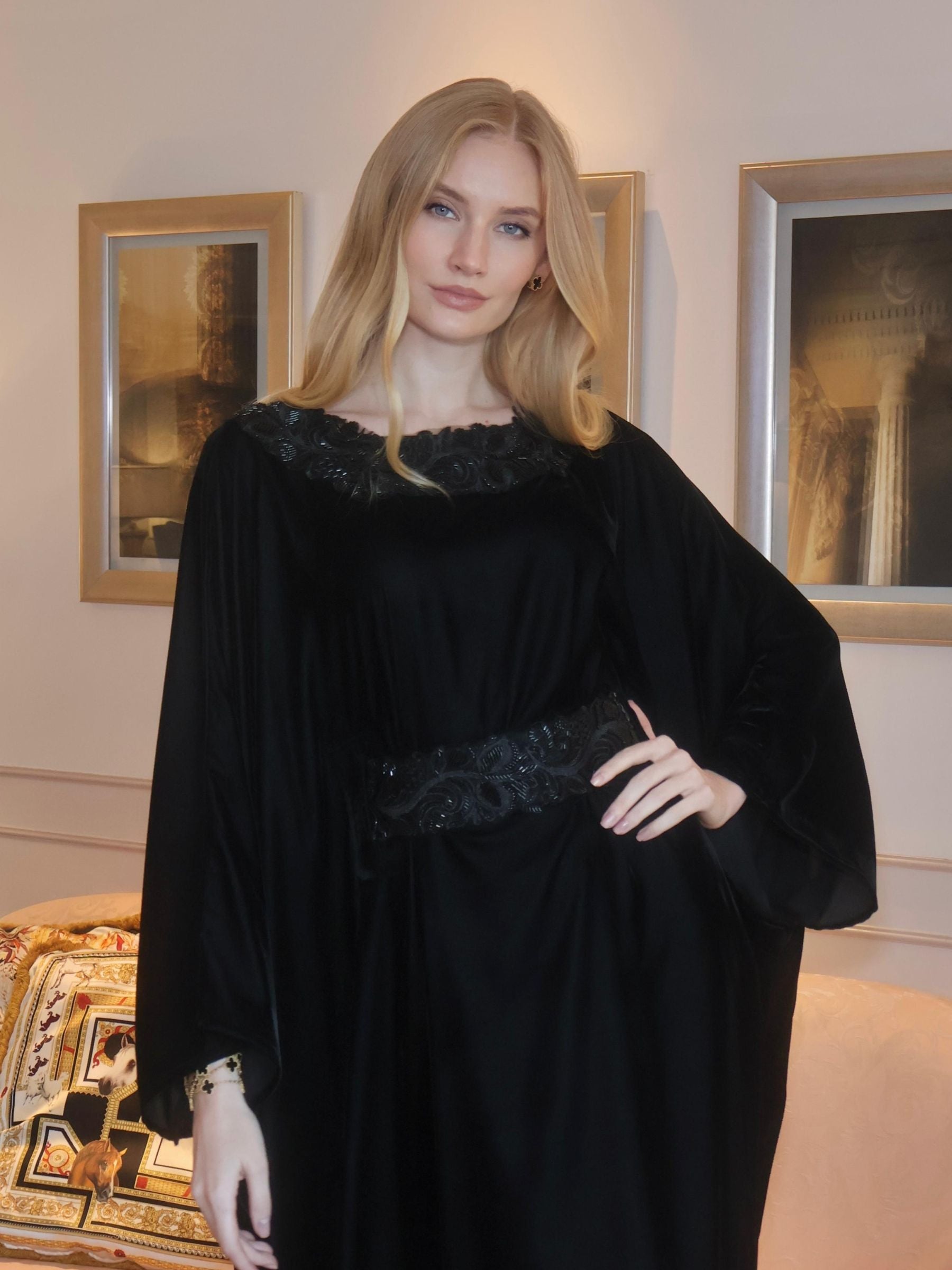 Woman wearing a black dress with floral embellishments.